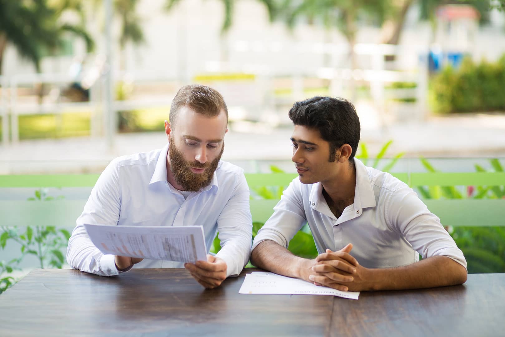 two focused business men meeting working outdoor cafe scaled